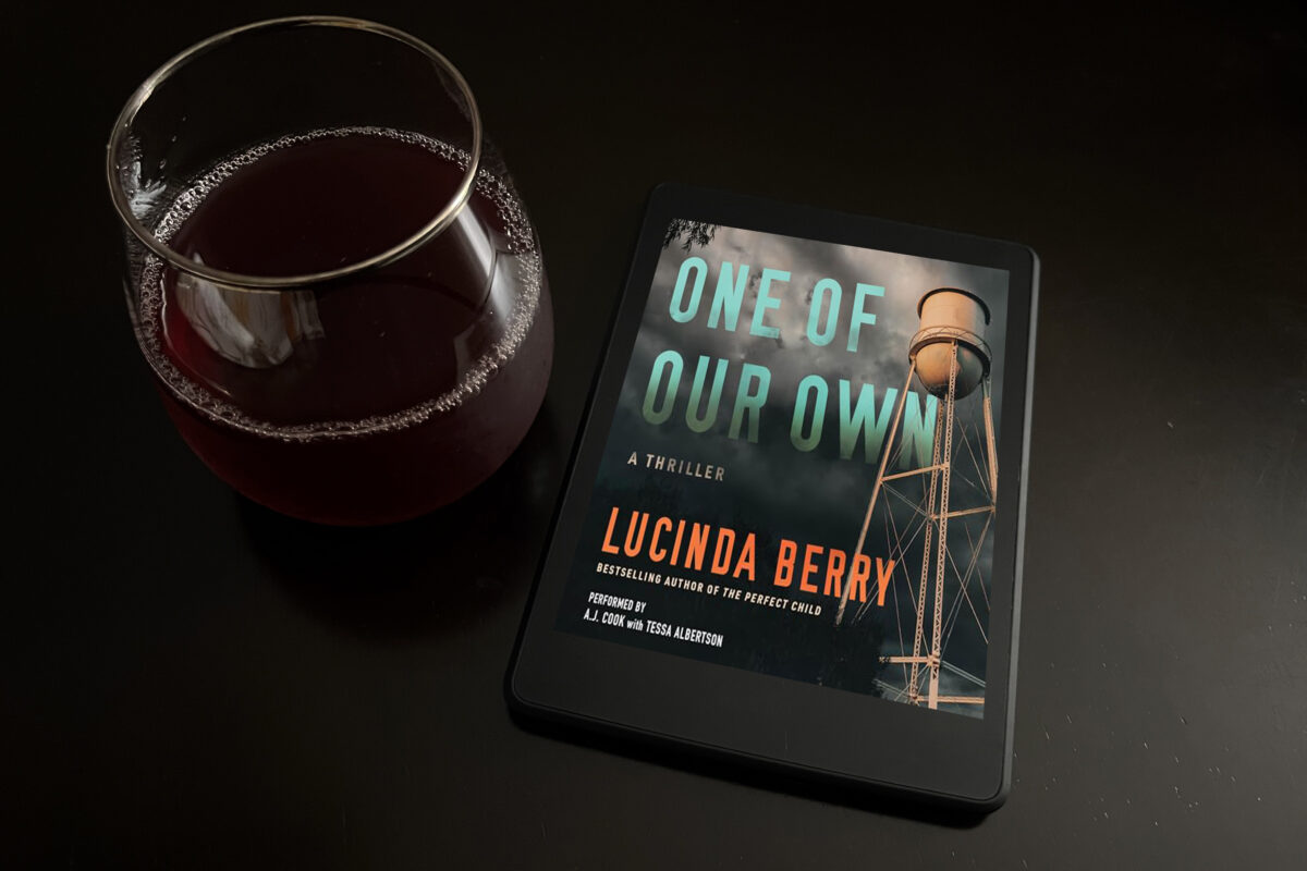 One of Our Own by Lucinda Berry, narrated by A.J. Cook and Tessa Albertson book photo by Erica Robyn Reads